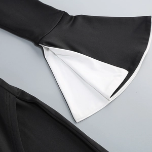 Detail of elegant flared sleeves featuring a black exterior and white contrast lining