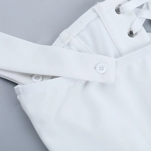 Detail of white lace-up corset top with silver metal eyelets and textured fabric