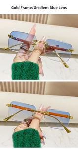 Close-up of rimless gold metal sunglasses with blue gradient lenses and wood grain temples