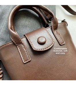 Detailed view of brown litchi grain PU leather texture and stitching on crossbody bucket bag