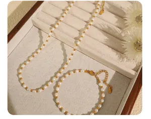 Detail of baroque pearl and gold bead jewelry set featuring S.STEEL engraved metal tags