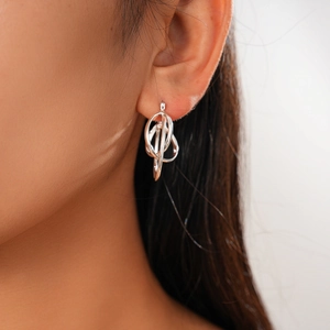 Close-up of geometric multi-ring interlocking silver earrings on model's ear