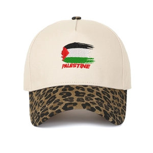 Primo piano del ricamo della bandiera della Palestina su un cappello leopardato beige.