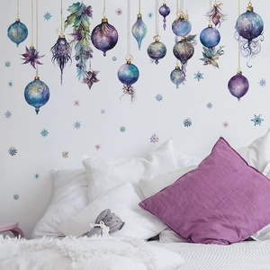 Self-adhesive Christmas snowflake wall decals with blue and purple baubles over a cozy bed