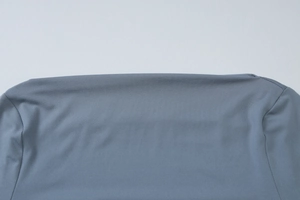 Detailed close-up of blue-grey fabric texture and stitching on long sleeve dress
