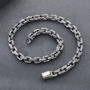 Macro detail of industrial style silver steel chain with hammered texture and buckle