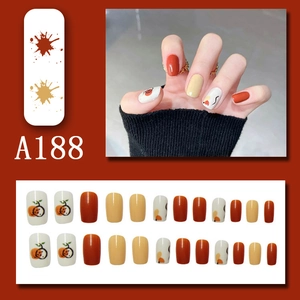 Short square press-on nails in pumpkin orange and ginger yellow with artistic hand-painted designs