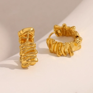 Detail view of gold earrings with unique crumpled metal texture and 18K gold plating