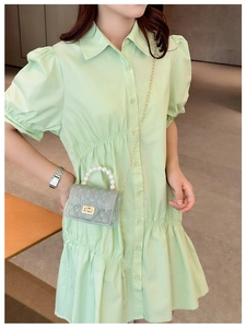 Close-up of light green jelly bag with pearl handle and golden chain on model