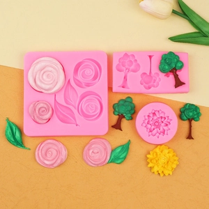 Detailed pink silicone molds featuring roses, trees, and leaves for fondant cake decoration