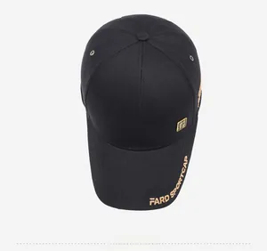 Macro detail of black cotton baseball cap with gold embroidery and square metal logo