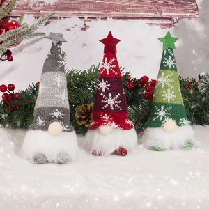 Three glowing Christmas gnomes with knitted hats and stars in a snowy festive scene