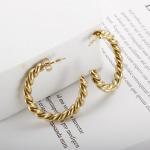 Détail de boucles d'oreilles torsadées plaquées or 18 carats avec fermoir papillon