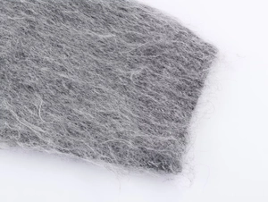 Detailed macro view of gray plush knit fabric with soft fuzzy texture for autumn sweaters