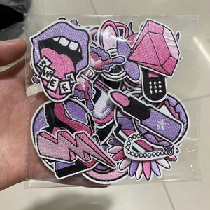 Detailed shot of purple and pink embroidered patches including lips and diamonds in package