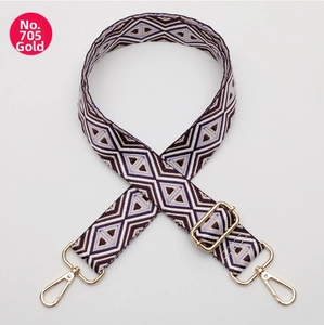 Detail of adjustable bag strap featuring purple geometric diamond patterns and gold metal hooks