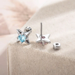 Elegant silver four-pointed star stud earrings with blue gemstone and screw-back closure