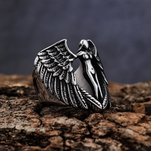 Gothic fallen angel wing ring in vintage silver stainless steel on dark wood background