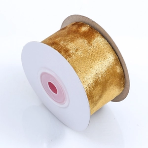 Close-up of golden velvet ribbon roll with metallic luster for DIY Christmas crafts