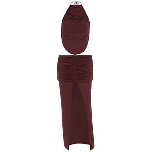 Detail of burgundy two-piece set featuring pleated halter top and high-slit maxi skirt