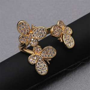 Adjustable gold butterfly ring with micro-pave zircons shown on a black cylinder display