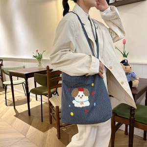 Detail of navy blue striped canvas tote bag featuring cute dog embroidery and Happy Day text