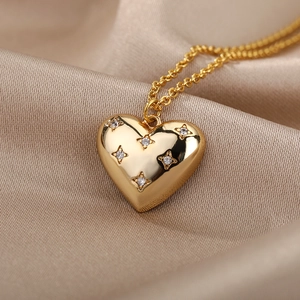 Macro detail of a golden heart pendant necklace with starburst rhinestones on silk