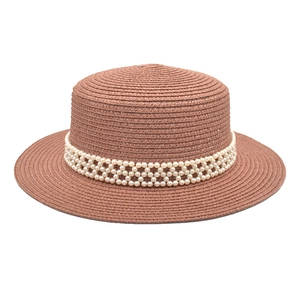 Detailed close-up of woven pearl band decoration on a French flat top boater straw hat