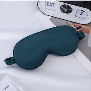 Detail of dark teal faux silk sleep mask showing smooth fabric and elastic strap
