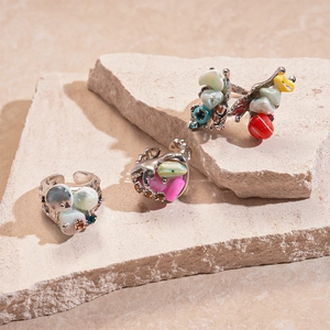 Colorful irregular stone open rings with silver metal base on decorative stone slabs