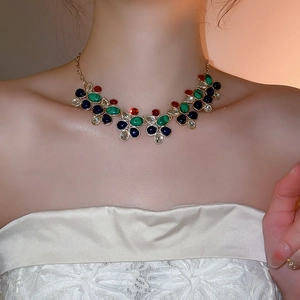 Close-up of model wearing luxury gold necklace with vibrant multi-color crystal pendants