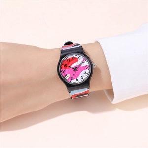Close-up of children's quartz watch with pink camouflage strap worn on wrist