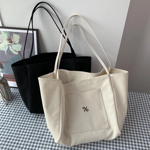 Detail view of large canvas tote bags in white and black with printed percent sign