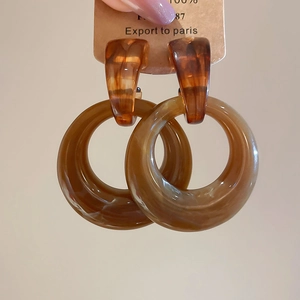 Detailed close-up of retro amber resin hoop earrings with elegant marble texture detail
