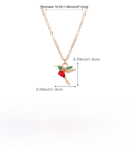 Rose gold hummingbird pendant necklace featuring red and green gemstone accents on a chain
