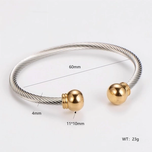 Detail view of gold and silver cable twist bangle with dimension labels 60mm and 4mm