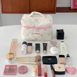 Beauty case trapuntato bianco con ampia capacità e vari prodotti per il trucco