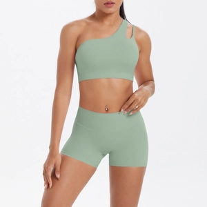 Detail view of one-shoulder sage green sports bra and high-waisted shorts set