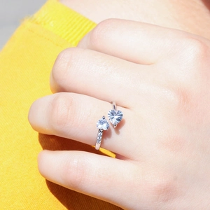 Close-up of silver heart ring with sparkling zircon inlays worn on a finger