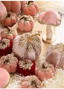 Macro detail of velvet mushroom ornaments with gold sequins on wooden tray