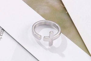 Close-up of polished stainless steel cross ring with an adjustable open band design