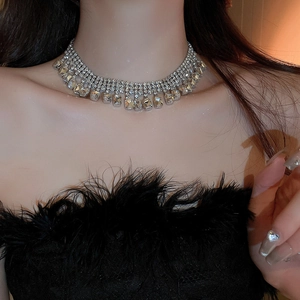 Gros plan d'un collier à pompons en strass argenté étincelant sur un mannequin chic