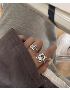 Detailed view of sterling silver rings with square and star shaped crystals on hand