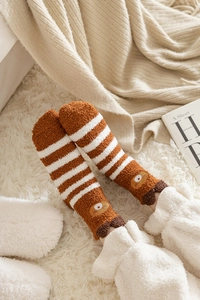 Detail of coral fleece brown striped socks with cute cartoon bear face embroidery