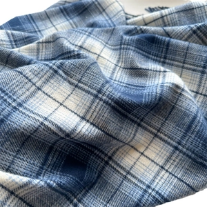 Blue and white checkered faux cashmere scarf with soft texture and tassel details