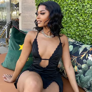 Detail of sexy black lace trim on a satin V-neck dress worn by a model outdoors