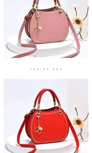 Detailed view of semi-circular leather handbags in red and pink with gold leaf charms