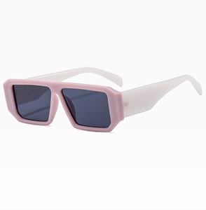Detail view of square sunglasses featuring two-tone pink and white resin frames and grey lenses