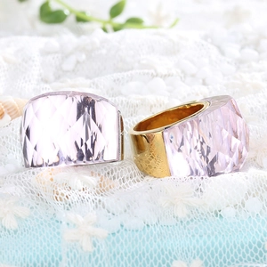 Macro detail of lavender crystal ring with gold faceted metal band on lace