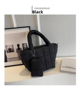 Detail of a black quilted puffer tote bag with matching hanging coin purse accessory